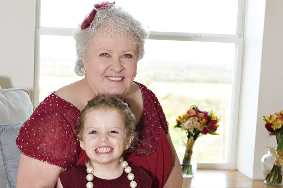Grand mère avec sa petite fille sur les genoux toutes les deux sur un canapé