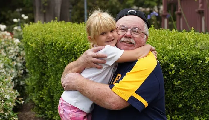 grand père tenant sa petite fille dans ses bras