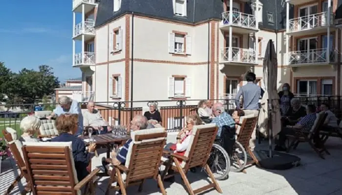 Photo d'un groupe de senior sur la terrasse d'une résidence senior pendant le COVID