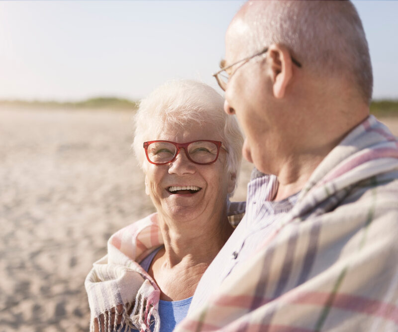 Couple de senior souriant sur une plage ensoleillé