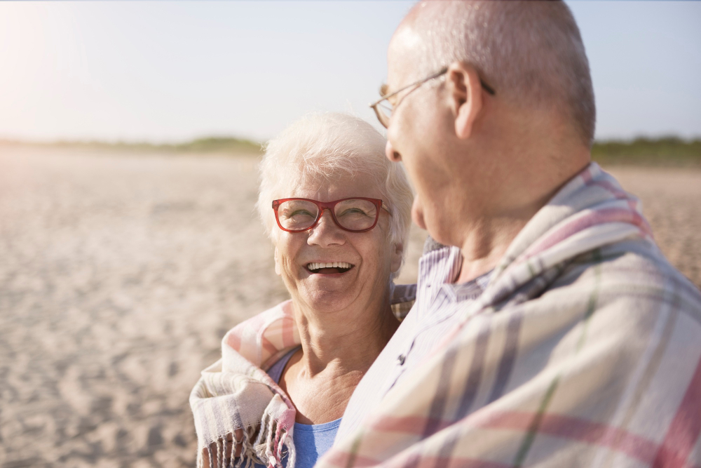 Couple de senior souriant sur une plage ensoleillé