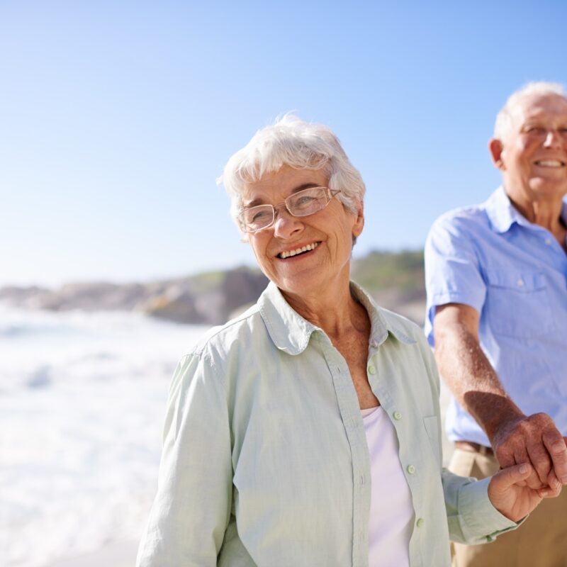 Couple senior marchant main dans la main sur la plage