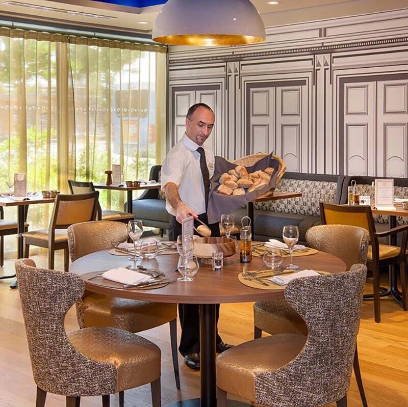 Photo d'un serveur de restaurant d'une résidence senior Domitys dans la salle de restaurant