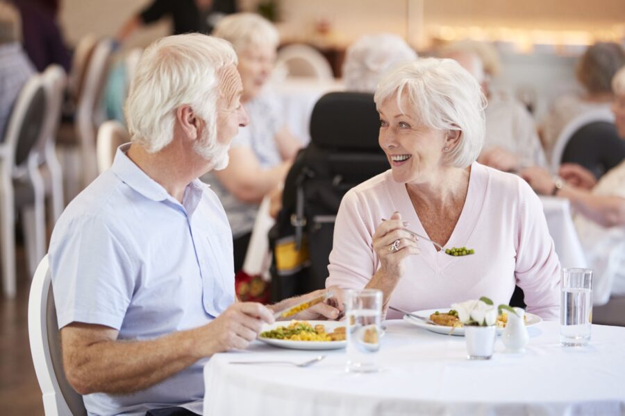 Couple senior partageant un repas dans un maison de retraite