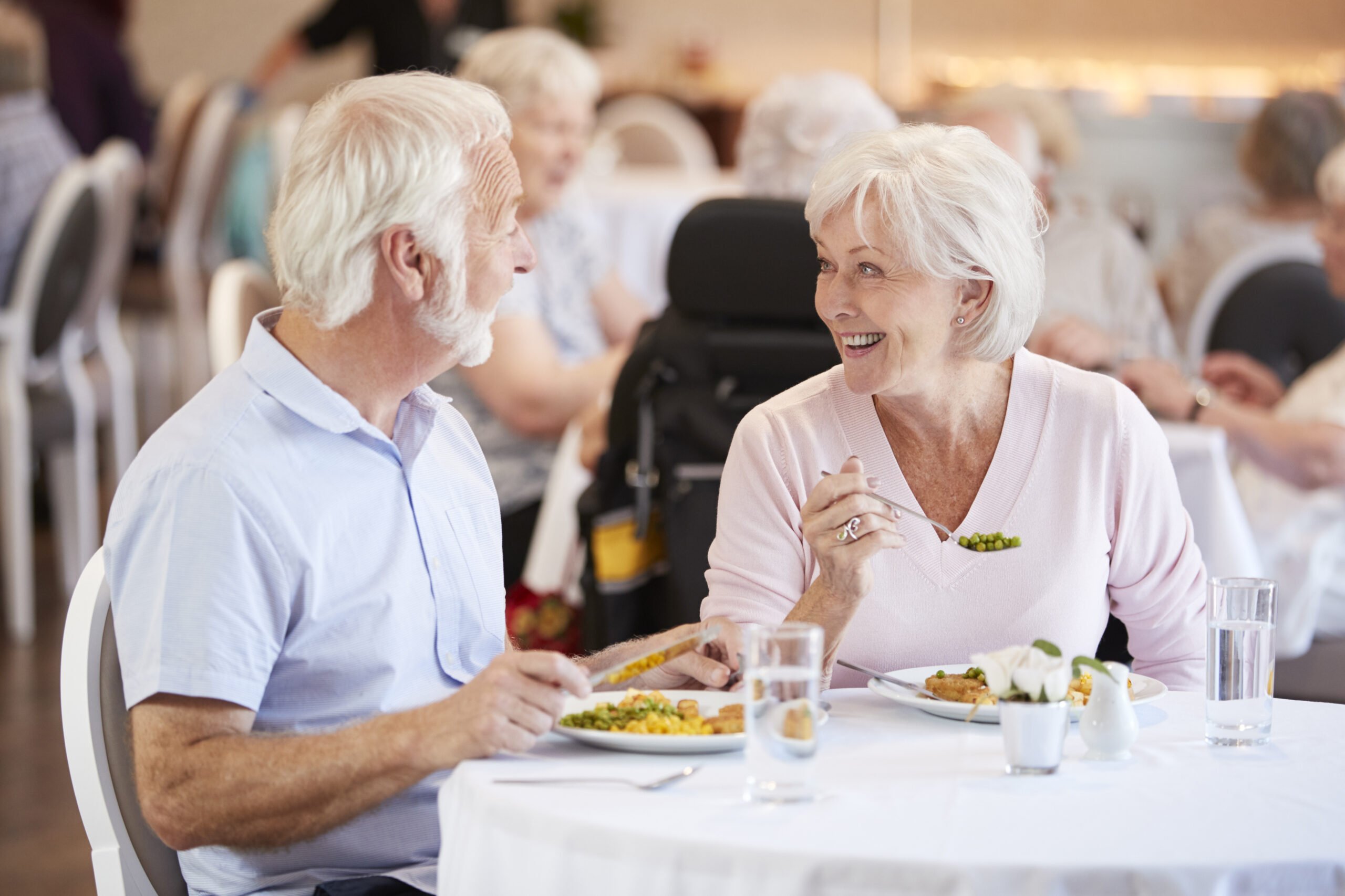 Couple senior partageant un repas dans un maison de retraite