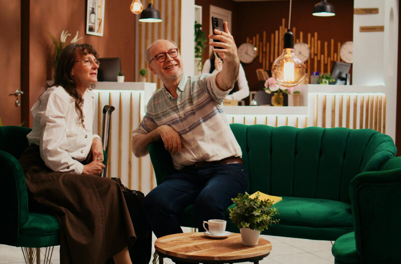 Couple senior se prenant en photo à l'accueil d'une résidence senior