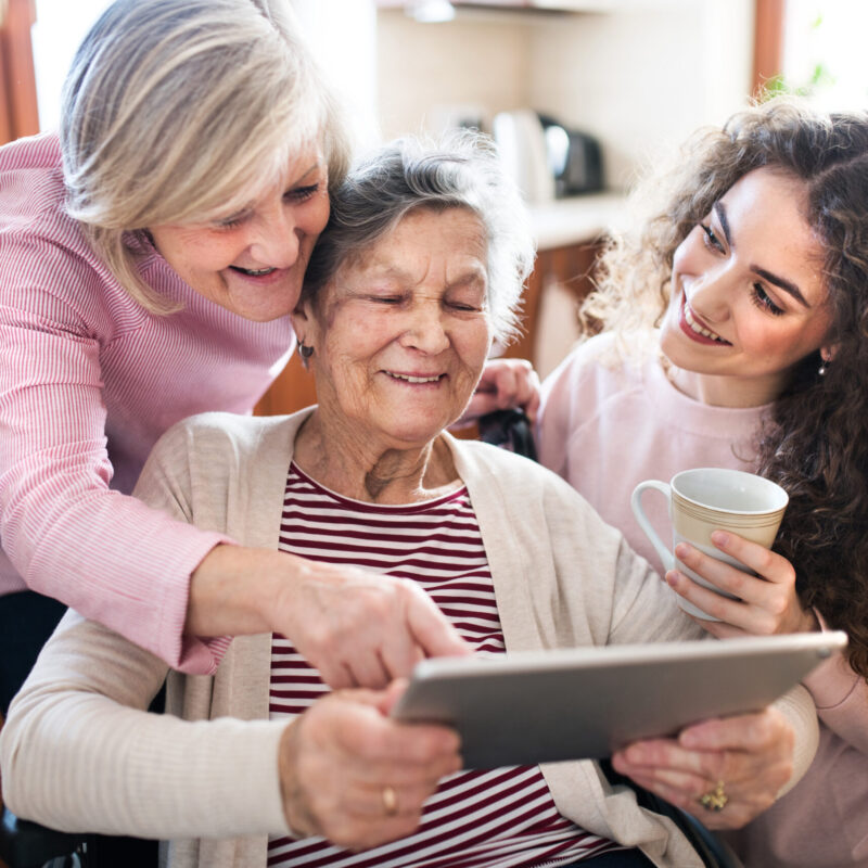 Femme senior avec sa famille regardant la tablette