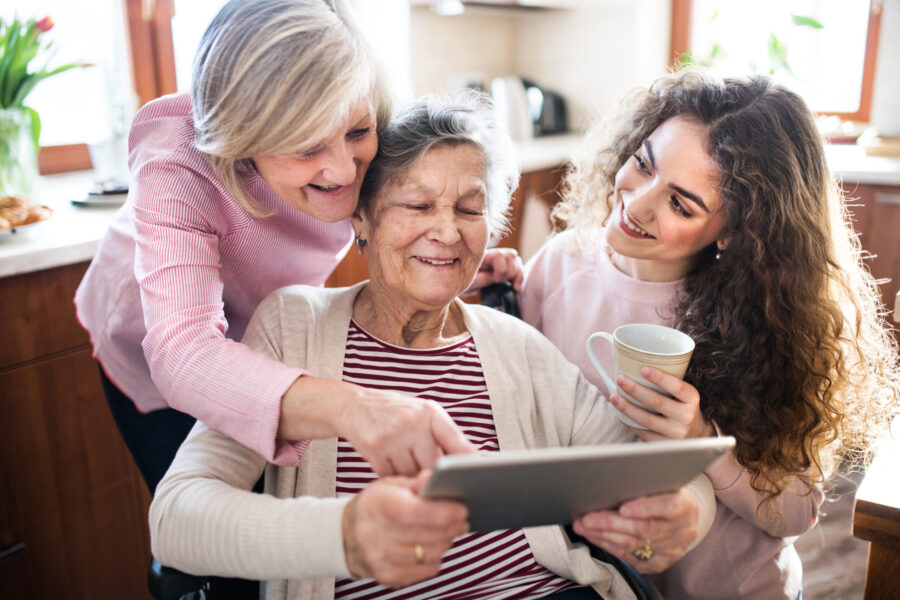 Femme senior avec sa famille regardant la tablette