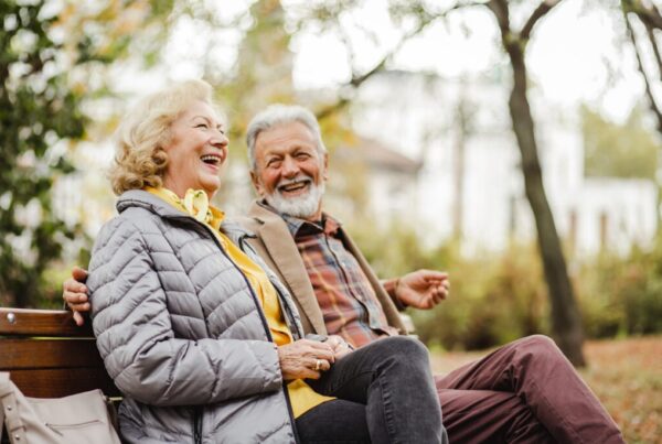 Photo d'un couple senior sur un banc rigolant