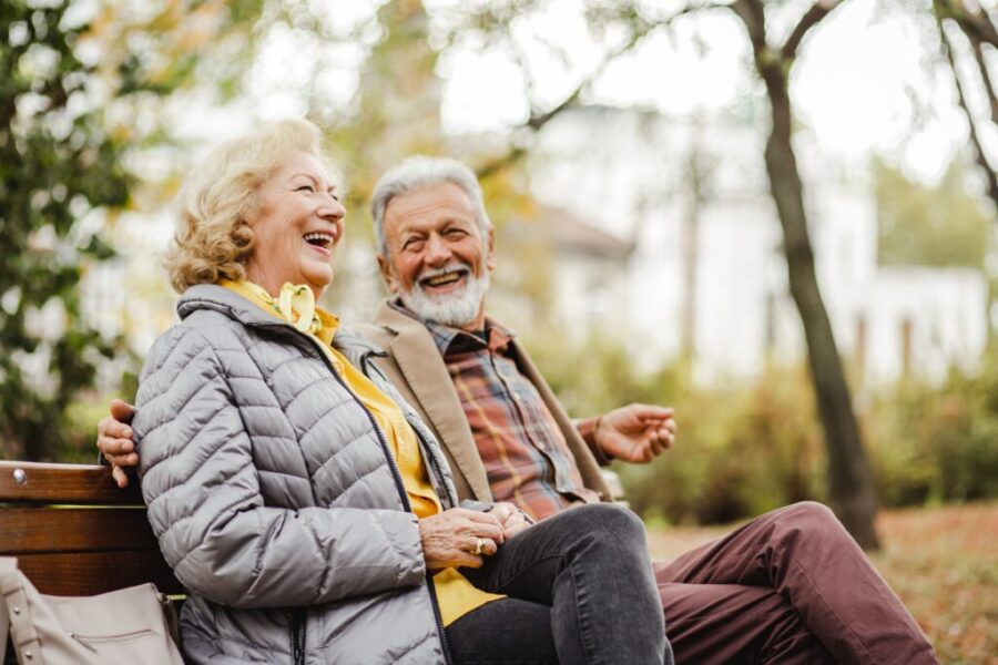 Photo d'un couple senior sur un banc rigolant