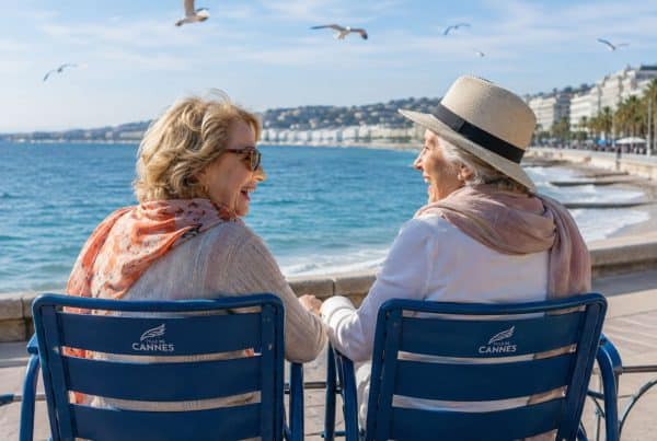 Deux seniors rigolent ensemble sur la Croisette, face à la mer