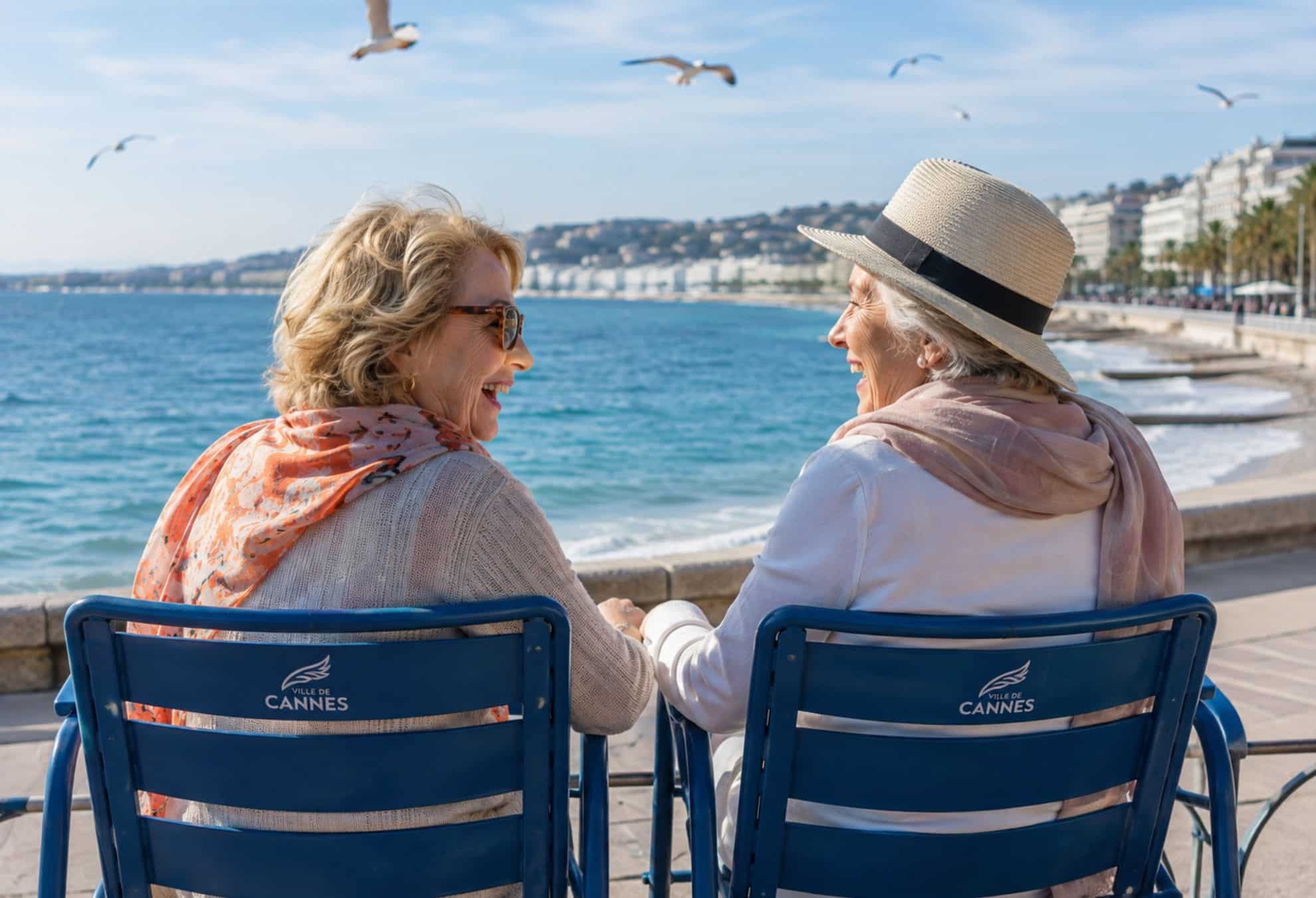Deux seniors rigolent ensemble sur la Croisette, face à la mer